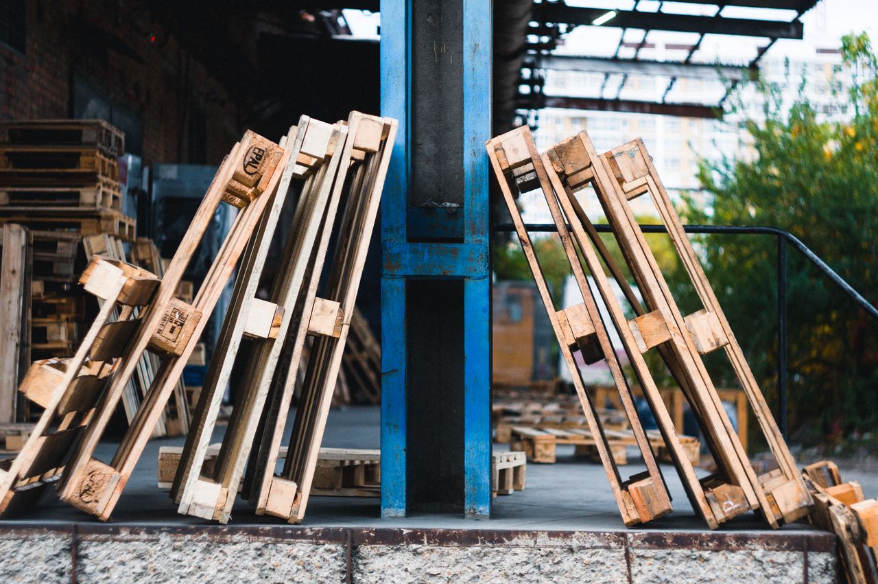 Close-up view of wooden pallets in an outdoor industrial warehouse setting.
