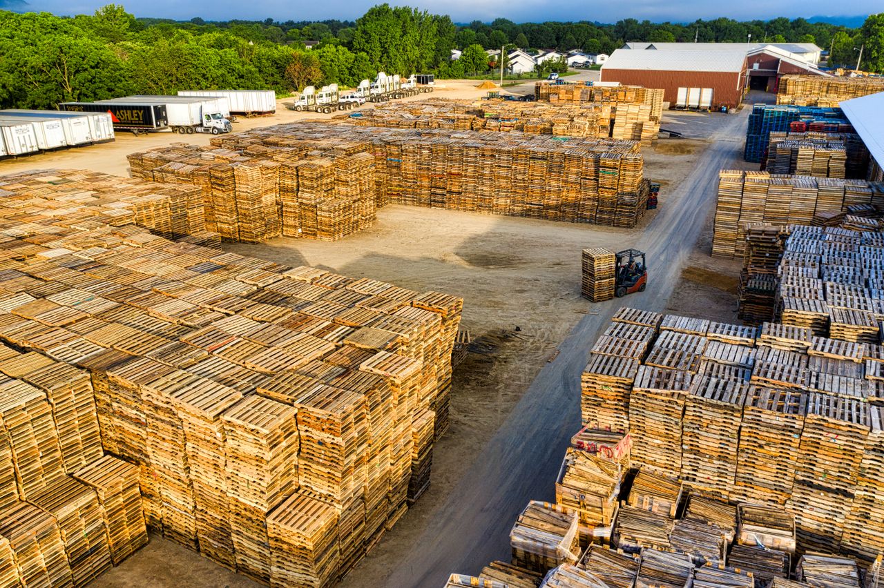 Aerial view showcasing large stacks of wooden pallets in an outdoor storage facility in Lake City, MN.
